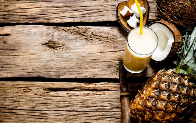 Cocktail Pina Colada. Verse cocktail met kokos, rum en ananas op een houten tafel. Vrije ruimte voor tekst.