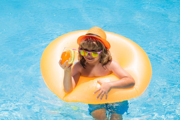 Cocktail in the pool the child has a rest in swimming pool with a fruit drink summer vacation