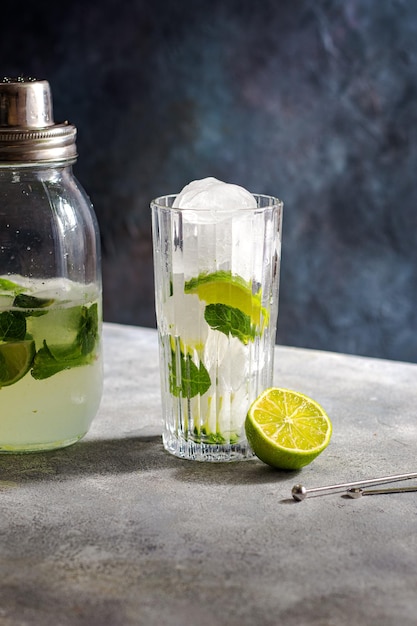 Cocktail preparation glass with lime ice cubes mint tools for cocktail barman bartender equipment shaker with mojito