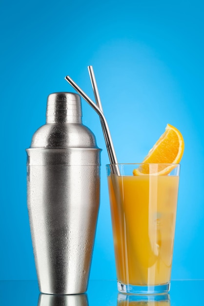 Cocktail shaker and orange cocktail