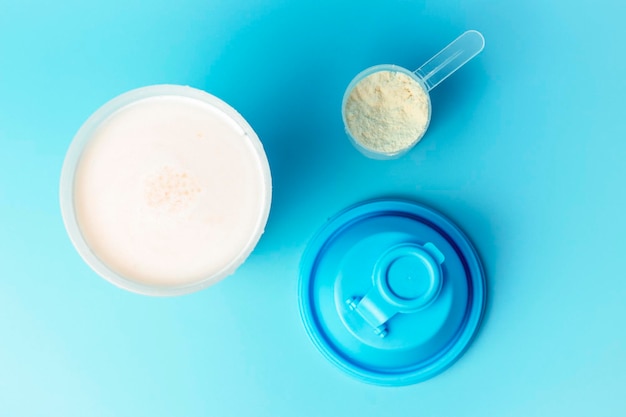 Cocktail and spoon with protein on a blue background top view