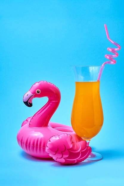 Cocktail tequila zonsopgang met opblaasbaar roze flamingo zwembad speelgoed op blauwe achtergrond zomer concept