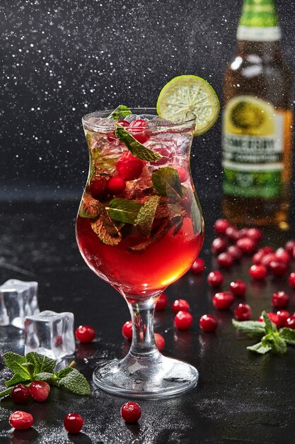 Cocktail with apple cider cranberries mint and lime