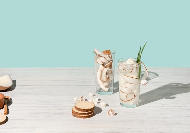 Cocktail with coconut in glass on blue and white wooden table background tropical bar drink