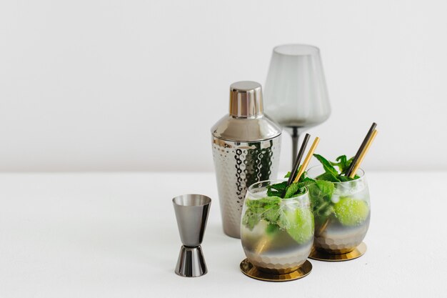 Cocktail with lime, mint and ice and  bar accessories on. Summer drinks.