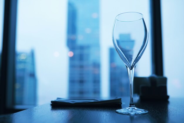 Cocktailglazen op de vensterbank door het glas van een hoog gebouw