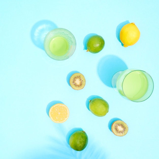 Коктейли в стакане с лаймом и лимоном на синем фоне.