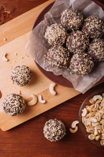 Cocoa balls, chocolate truffles cakes on board on wooden table