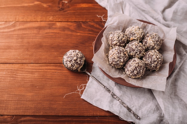 Cocoa balls, chocolate truffles cakes on board on wooden table