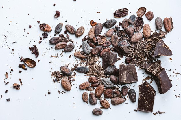 カカオ豆と白い背景の破れたチョコレート トップビュー コピースペース 浅いドフ