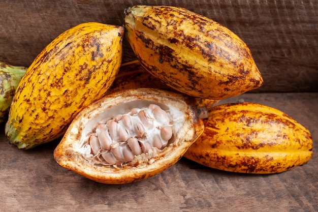 Cocoa beans and cocoa pod on a wooden surface.