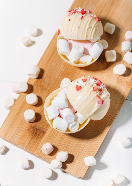 Foto bomba al cacao in tazza con marshmallow, il cioccolato caldo si scioglie quando il latte caldo