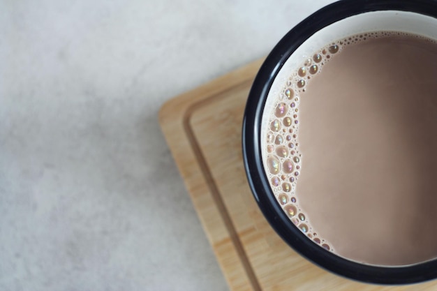 Cocoa drink in a mug on a wooden board on the table Top view copy space