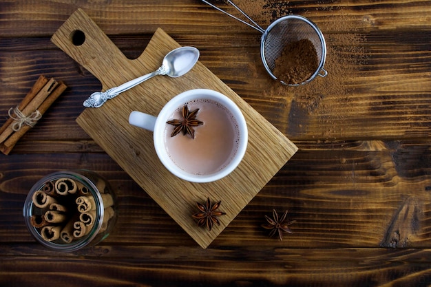 Cocoa drink in the white cup on the wooden background Top view Closeup