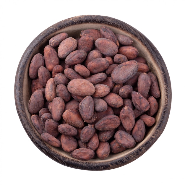 Cocoa fruit in a wooden bowl, raw cacao beans isolated on a white background