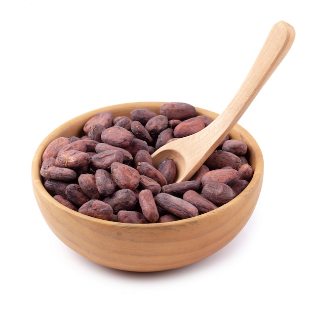 Cocoa fruit in a wooden bowl, raw cacao beans isolated on a white background