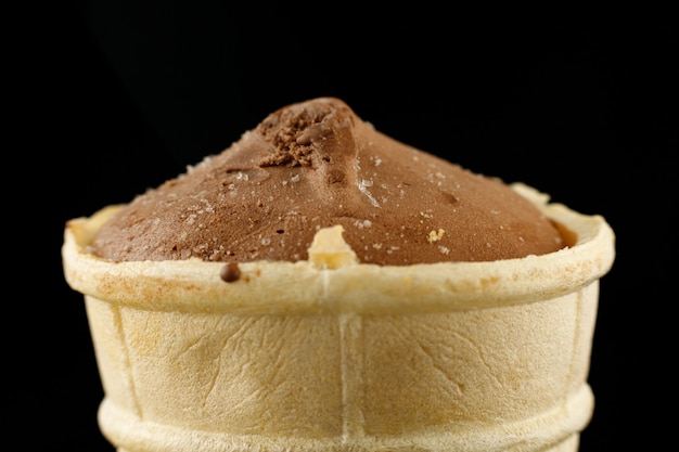 Foto gelato al cacao in una tazza di waffle sfondo nero