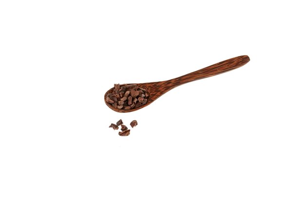 Cocoa nibs poured out of wooden spoon Cocoa nibs often added to cereals desserts smoothies