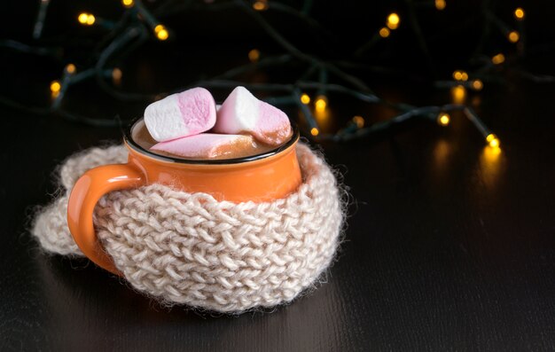 Cocoa in an orange mug on a black background.