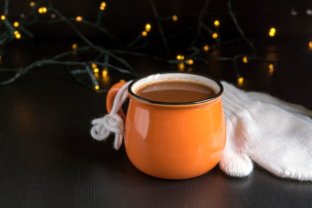 Cocoa in an orange mug on a black background.