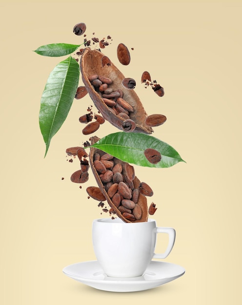 Cocoa pods and beans falling into cup on yellow background