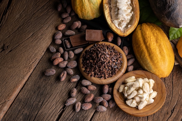 Cocoa pods, beans and powder on wooden table, top view