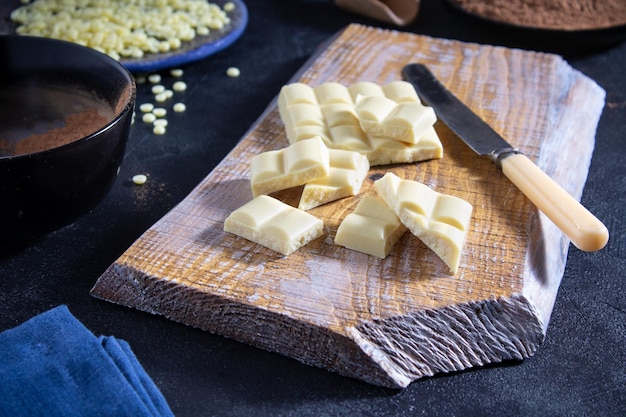 Cocoa powder and pieces of white chocolate on a wooden board