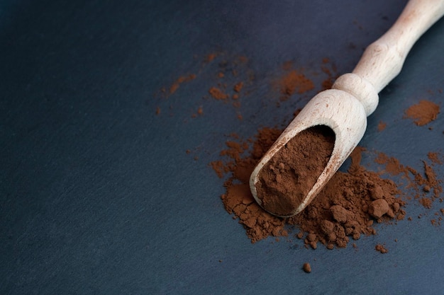 Photo cocoa powder in a wooden spoon