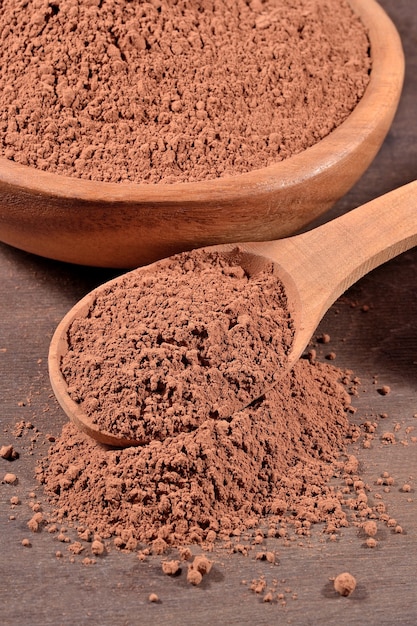 Cacao in polvere in un cucchiaio di legno