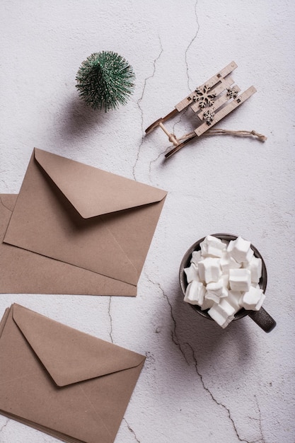 Cocoa with marshmallows craft envelopes and a Christmas tree on plaster Top and vertical view