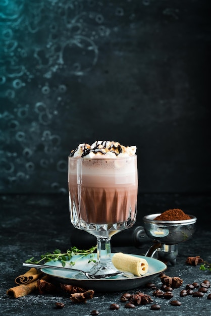 Cocoa with milk in a cup. Coffee. On a black stone background. Menu bar.