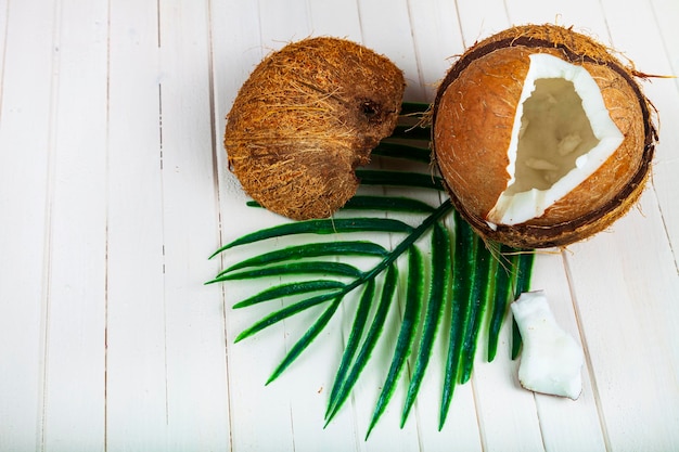 写真 白い木製の背景にココナッツとヤシの葉。