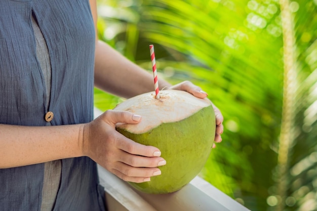 녹색 배경에 아름 다운 여성의 손에 코코넛. 코코넛 워터 컨셉의 장점