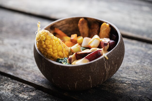 Coconut bowl full of balanced organic meal serving full of vegan variety foods.