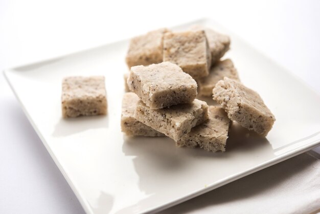 Coconut burfi or Nariyal Barfi is a sweet cake served in a plate selective focus