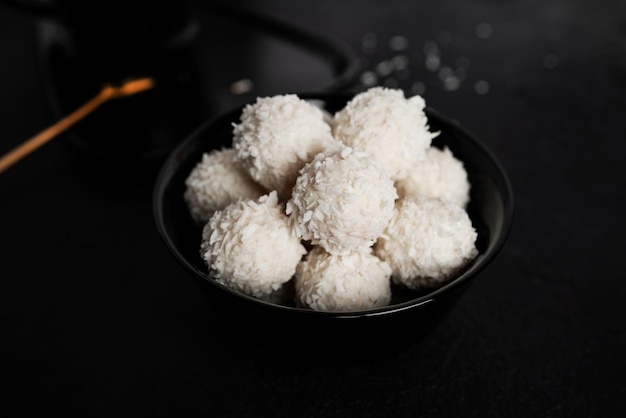 Caramelle al cocco con noci su sfondo scuro raffaello su sfondo nero foto di alta qualità