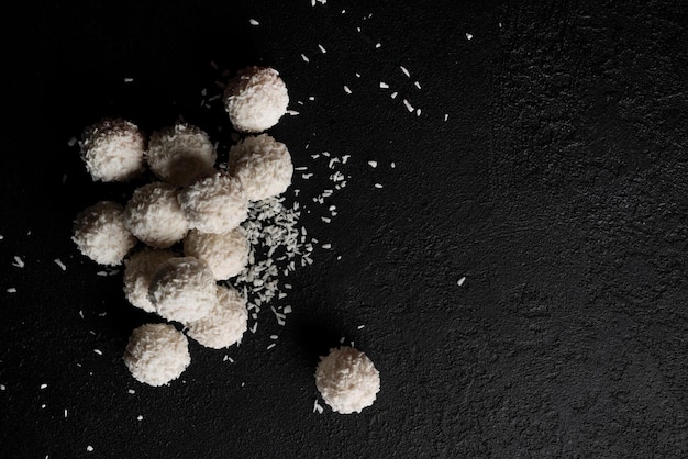 Coconut candies with nuts on dark background Raffaello on black background High quality photo