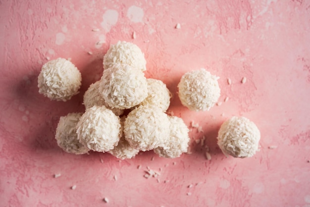 Кокосовые конфеты с орехами на розовом фоне Рафаэлло Фото высокого качества