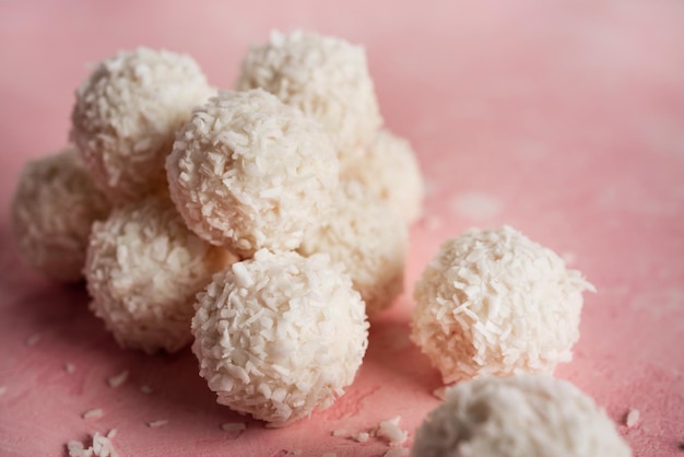 Caramelle al cocco con noci su sfondo rosa raffaello foto di alta qualità