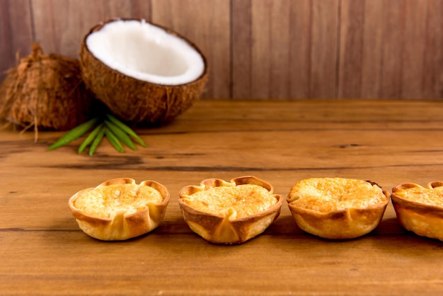 Coconut and coconut candy cocadinha on wooden background