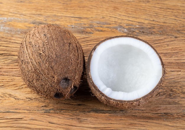 Coconut and cracked half fruit over wooden table