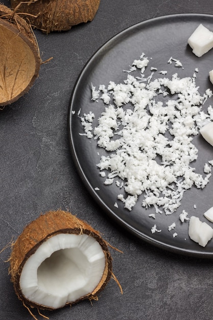 Coconut flakes on black ceramic plate