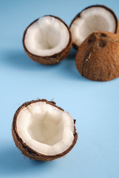 Coconut fruits on blue vibrant plain background, abstract food tropical concept, angle view macro