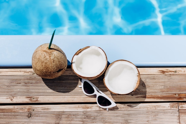 Coconut and glasses by the pool