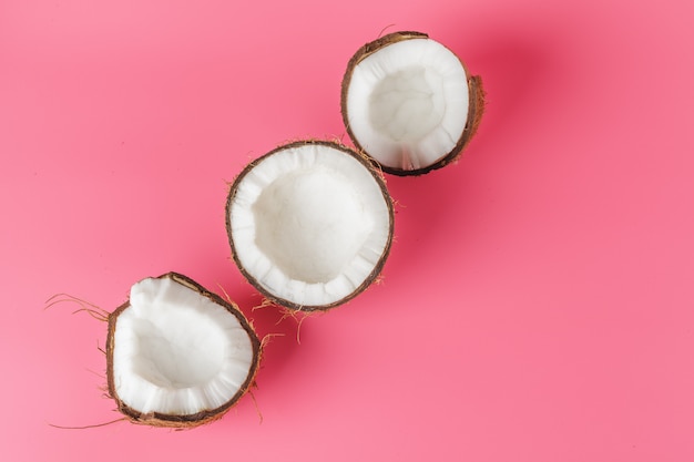 Coconut halves on a bright pink 