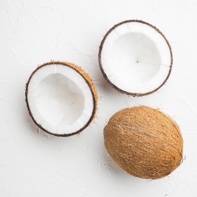 coconut halves, coconut pieces set, on white stone table