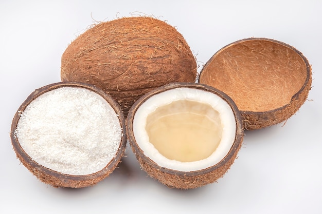 Coconut halves with coconut, milk and pulp on a white
