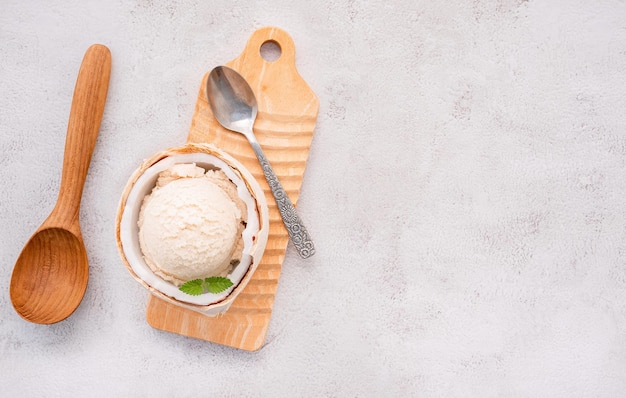 Coconut ice cream flavours in half of coconut setup on white stone background. Summer and Sweet menu concept.