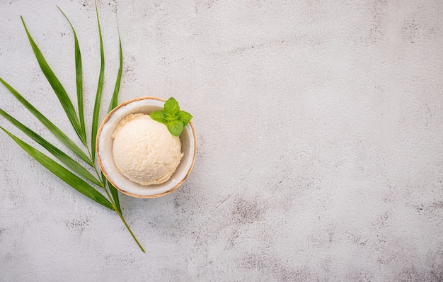 Gelato al cocco con foglie su un tavolo di cemento