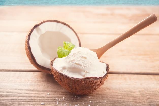 Coconut ice cream on the wooden table with mint leaf